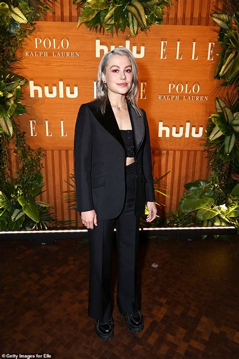 Phoebe Bridgers shows off her booty in a BACKLESS suit and。